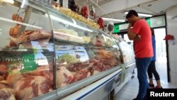 A man looks at meat on display inside a butcher shop in Buenos Aires, Argentina, Oct. 29, 2018. 