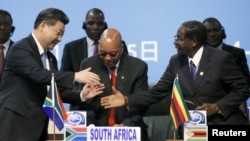 FILE - China's President Xi Jinping, left, shakes hands with Zimbabwe's President Robert Mugabe, right, while South Africa's President Jacob Zuma looks on during a Forum on China-Africa Cooperation in Sandton, Johannesburg, Dec. 4, 2015.