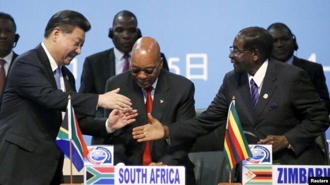 FILE - China's President Xi Jinping, left, shakes hands with Zimbabwe's President Robert Mugabe, right, while South Africa's President Jacob Zuma looks on during a Forum on China-Africa Cooperation in Sandton, Johannesburg, Dec. 4, 2015.