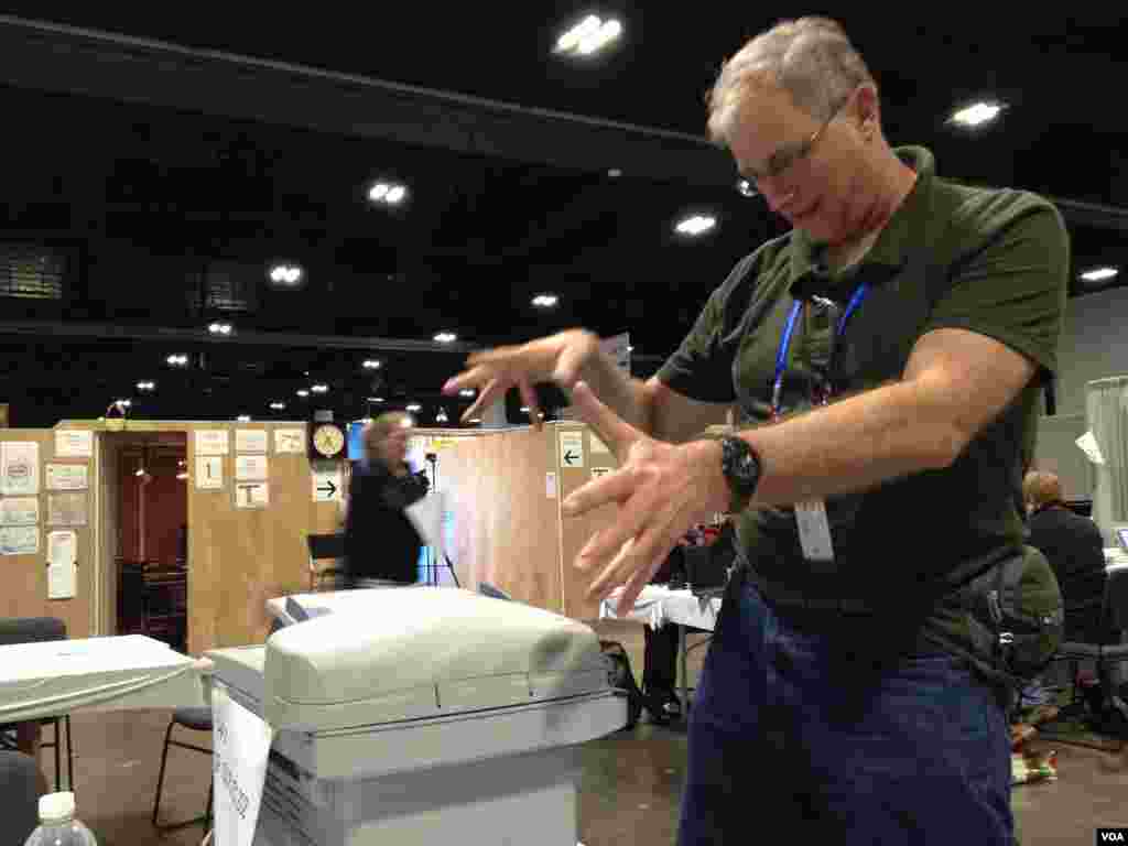 Teknisi VOA Woody Crawford sedang membetulkan printer di markas VOA di Tampa Convention Center (Ade Astuti/VOA).