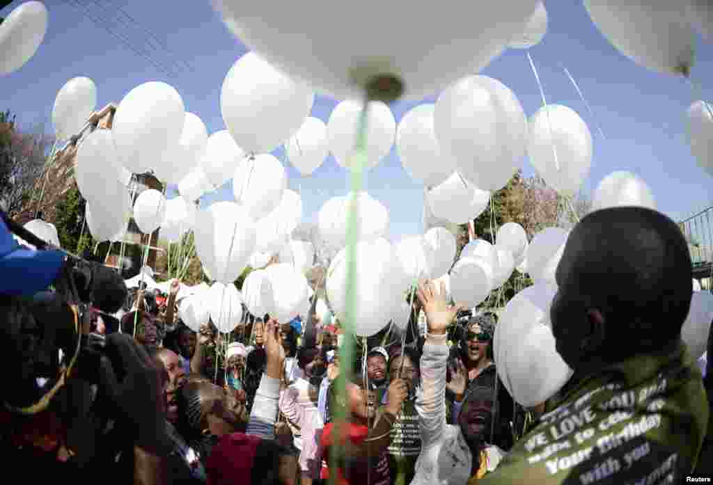 Children release 95 white balloons to mark the upcoming birthday of ailing former South African President Nelson Mandela outside the Mediclinic Heart Hospital in Pretoria, June 27, 2013.