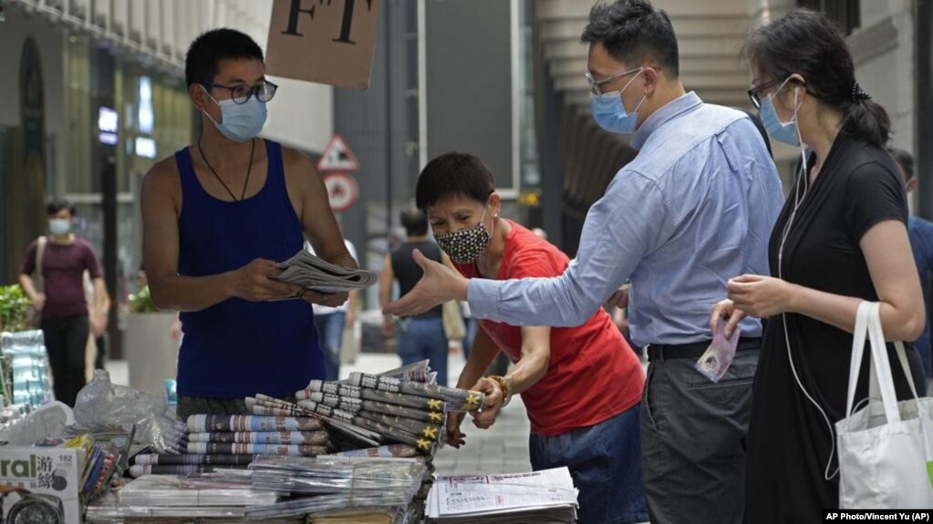 周五（6月18日），路人在香港街头购买《苹果日报》。该报周四被警方突袭，并有5名高管和记者被拘捕。（美联社照片）(photo:VOA)