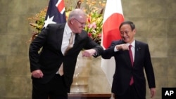 PM Australia Scott Morrison dan PM Jepang Yoshihide Suga berjabat tangan "siku" dalam pertemuan di Tokyo, Jepang Selasa (17/11). 