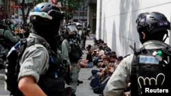Para demonstran anti-pemerintah duduk ketika mereka ditahan selama protes waktu makan siang ketika pembacaan kedua dari hukum lagu kebangsaan kontroversial terjadi di Hong Kong, Cina 27 Mei 2020. (REUTERS / Tyrone Siu)