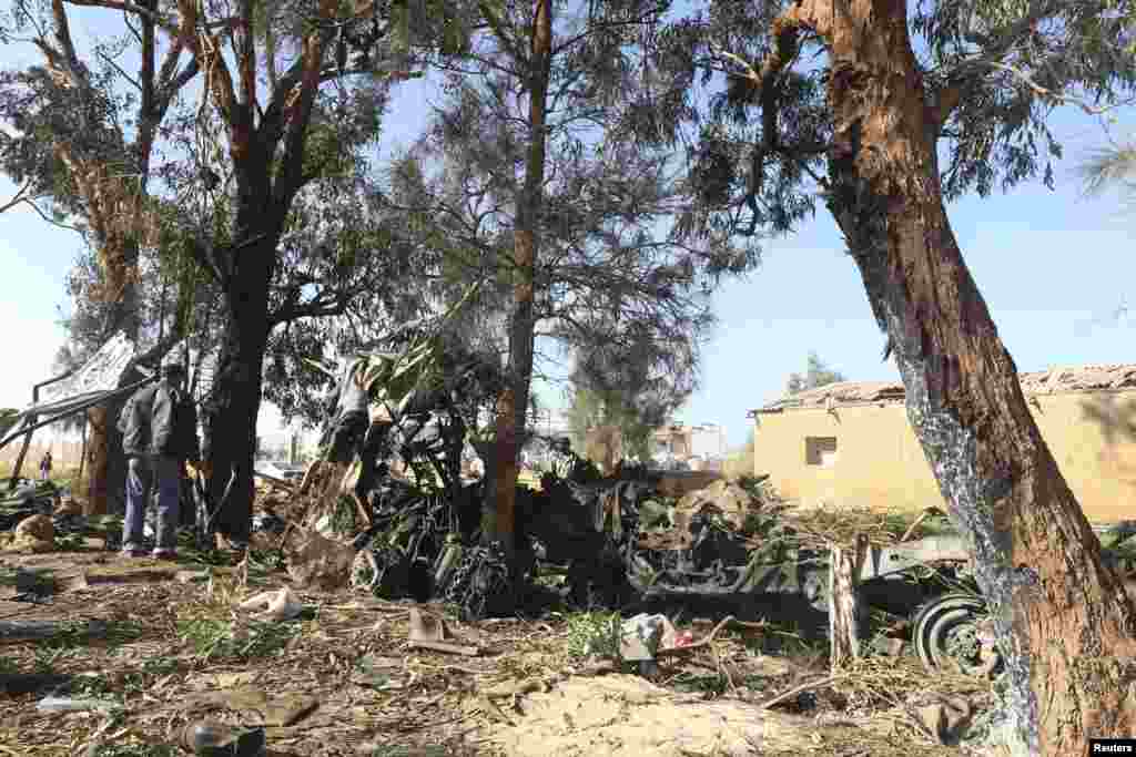 Men look at the scene near a military base 50 km outside Benghazi, after a suicide bomber detonated a truck packed with explosives at an army checkpoint, Barsis, Libya,&nbsp;Dec. 22, 2013.&nbsp;