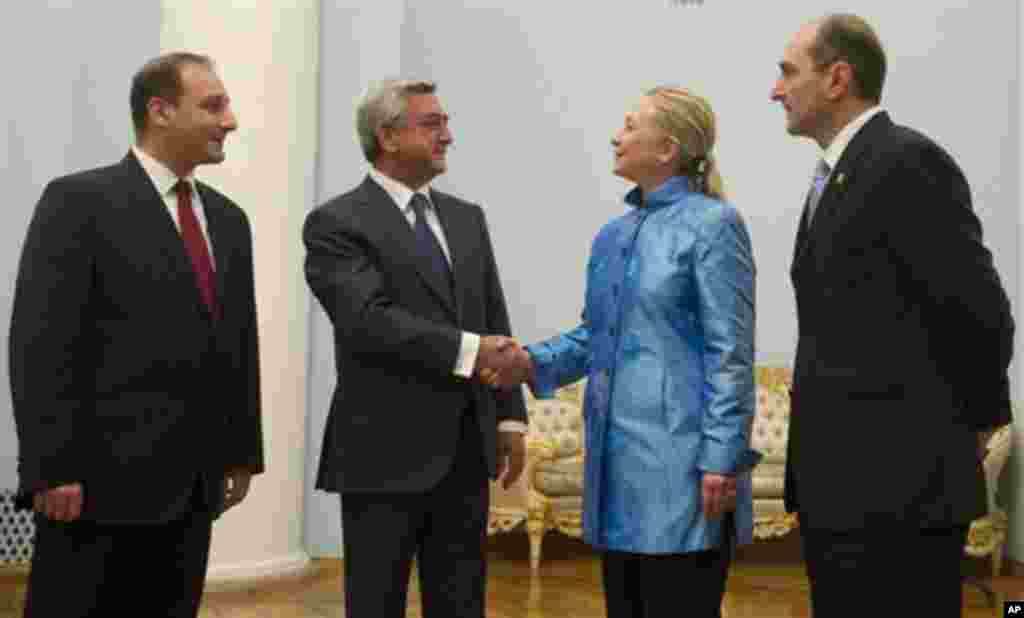 Armenian President Serzh Sarkisian, 2nd left, shakes hands with US Secretary of State Hillary Clinton Monday June 4, 2012 alongside translators before meetings at the presidential palace in Yerevan. (AP Photo/Saul Loeb, Pool)