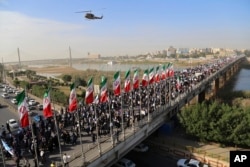 In this photo provided by Mehr News Agency, demonstrators attend a pro-government rally in the southwestern city of Ahvaz, Iran, Jan. 3, 2018.