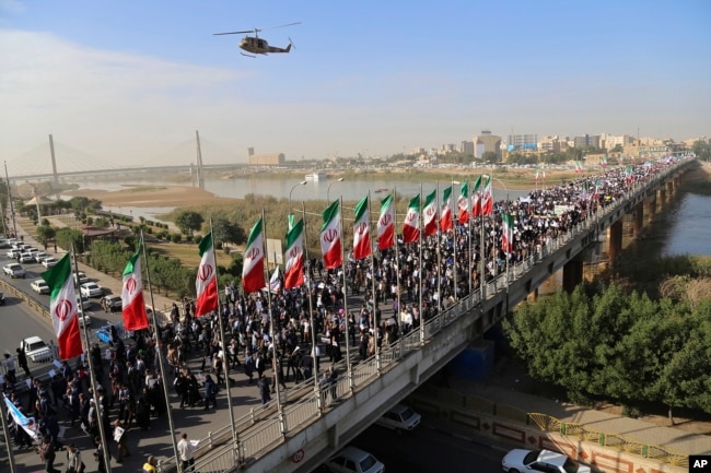 In this photo provided by Mehr News Agency, demonstrators attend a pro-government rally in the southwestern city of Ahvaz, Iran, Jan. 3, 2018.