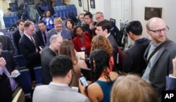 FILE - Reporters line up in hopes of attending a briefing in Press Secretary Sean Spicer's office at the White House in Washington, Feb. 24, 2017. White House held an off-camera briefing in Spicer's office, where they selected who could attend.