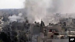 This image made from amateur video released by Shaam News Network and accessed Friday, June 8, 2012, purports to show explosions in the Khaldiyeh area of Homs, Syria. Syrian troops on Friday heavily shelled a rebel-held neighborhood in the flashpoint cent