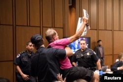 Un manifestante es arrestado mientras el candidato a la Corte Suprema, Brett Kavanaugh, testifica durante el tercer día de su audiencia de confirmación ante el Comité Judicial del Senado en el Capitolio, en Washington, el 6 de septiembre de 2018.