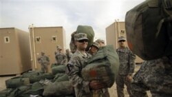 U.S. Army soldiers load trucks as they begin their journey home to their base in Texas