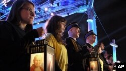 Faithful in Warsaw, Poland hold lanterns with an image of Pope John Paul II as they attend a prayer vigil honoring the late Pontiff on the eve of his beatification, Saturday, April 30, 2011.