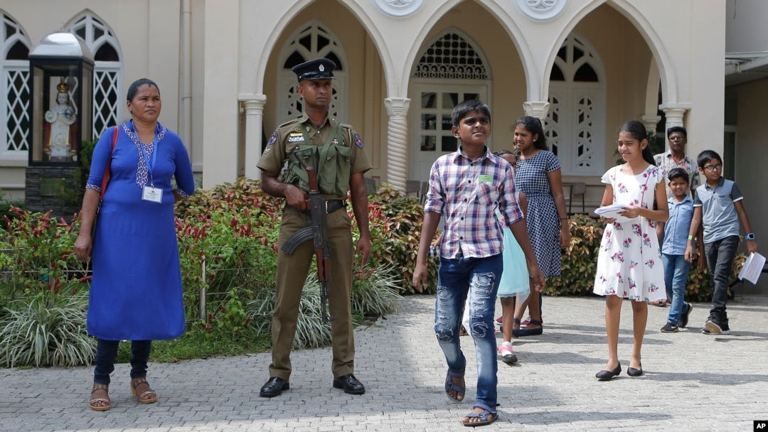 A Sri Lankan government soldier secures the premises of a Catholic church as devotees leave after Sunday Mass in Colombo, Sri Lanka, May 12, 2019.