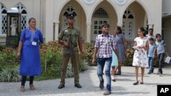 A Sri Lankan government soldier secures the premises of a Catholic church as devotees leave after Sunday Mass in Colombo, Sri Lanka, May 12, 2019.