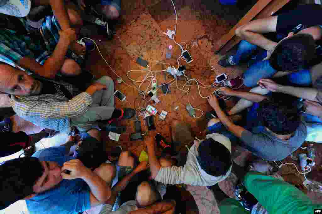 Migrants charge their mobile phones at the Eastern (Keleti) railway station in Budapest, Hungary. The EU is grappling with an unprecedented influx of people fleeing war, repression and poverty in what the bloc has described as its worst refugee crisis in 50 years.