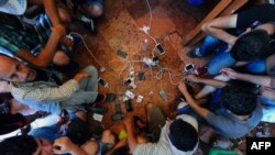Migrants charge their mobile phones at the Eastern (Keleti) railway station in Budapest on August 31, 2015. The EU is grappling with an unprecedented influx of people fleeing war, repression and poverty in what the bloc has described as its worst refugee 