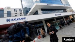 A TV correspondent reports in front of Halkbank headquarters in Atasehir, in the Asian part of Istanbul, Dec. 17, 2013.