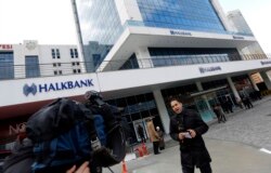 FILE - A TV correspondent reports in front of Halkbank headquarters in Atasehir, in the Asian part of Istanbul.
