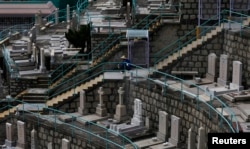 A cemetery worker rests at a graveyard in Hong Kong, May 29, 2014.