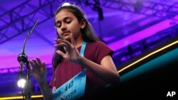 Naysa Modi, 12, from Frisco, Texas, types her word in the air while spelling correctly during the evening finals of the Scripps National Spelling Bee in Oxon Hill, Md., May 31, 2018.