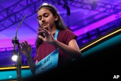 Naysa Modi, 12, from Frisco, Texas, types her word in the air while spelling correctly during the evening finals of the Scripps National Spelling Bee in Oxon Hill, Md., May 31, 2018.