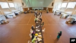Electoral workers engage in the vote tally verification process at the National Tallying Center