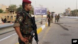 Iraqi security forces stand guard as they check motorists entering the heavily fortified Green Zone in Baghdad, Iraq, Oct. 5, 2015.