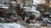 土耳其城市马拉蒂亚的地震灾民坐在房屋废墟上。 （2023年2月7日）