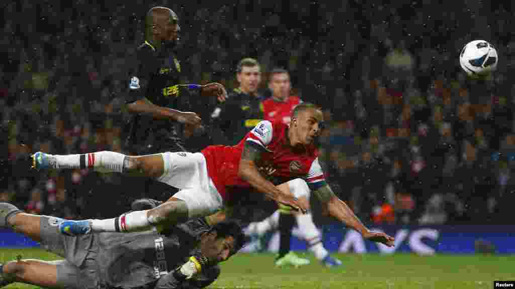 Theo Walcott of Arsenal scores against Wigan Athletic during their English Premier League soccer match in London, May 14, 2013.