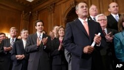 John Boehner es aplaudido por sus compañeros de bancada luego de aprobar una resolución que permite al gobierno seguir funcionando pero quitandole fondos al Obamacare.