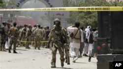 Seorang tentara NATO (tengah) terlihat di depan lokasi hotel Spozhmai di Danau Qargha, utara Kabul, Afghanistan (22/6). 