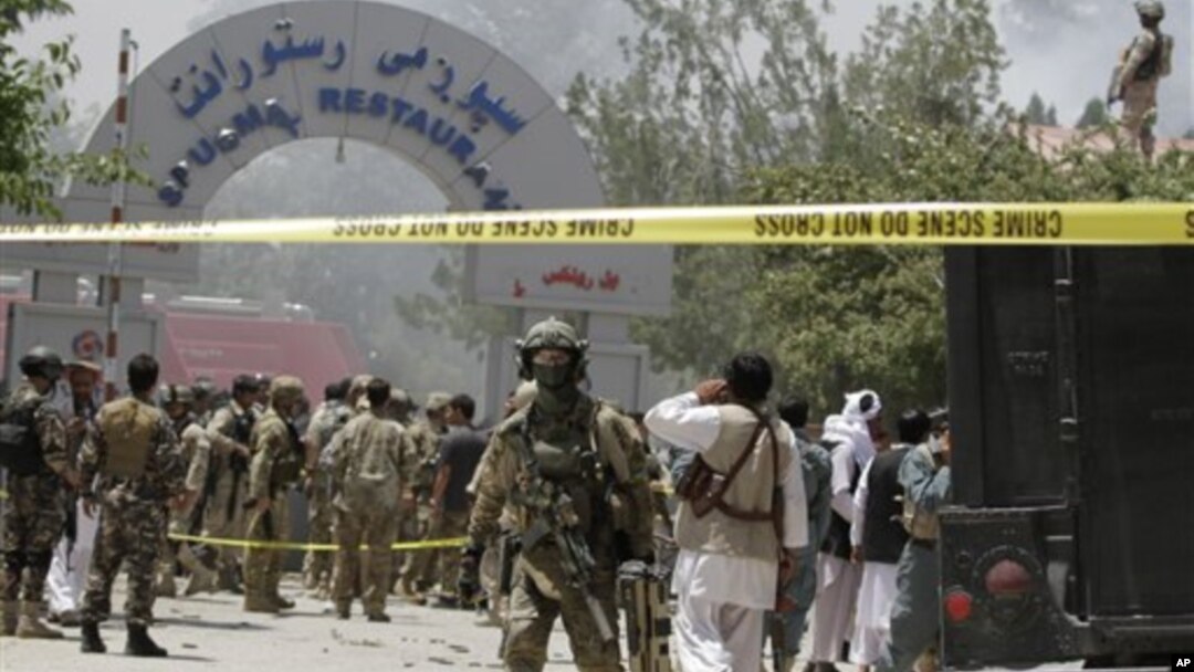 Seorang tentara NATO (tengah) terlihat di depan lokasi hotel Spozhmai di Danau Qargha, utara Kabul, Afghanistan (22/6). 