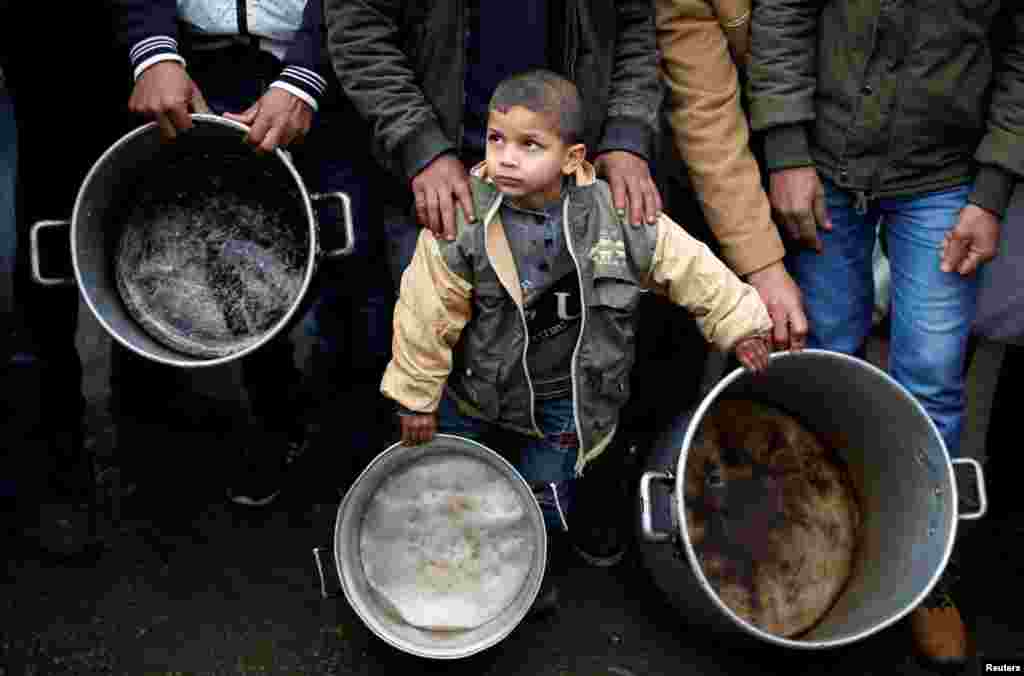 Seorang anak Palestina dengan membawa alat memasak, mengikuti aksi protes menentang pemotongan bantuan kemanusiaan, di luar kantor PBB di Gaza City, Jalur Gaza.