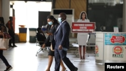 Des personnes portant des masques faciaux marchent à l'intérieur de l'aéroport international Nnamdi Azikiwe, le jour de sa réouverture pour les opérations aériennes nationales, à la suite de l'épidémie de COVID-19, à Abuja, au Nigéria, le 8 juillet 2020. REUTERS / Afolabi Sotunde