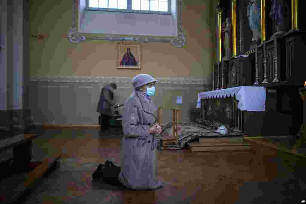 A woman prays during the Sunday Mass at the St. Trinity Church in a small town Tverecius, some 135km (83.1 miles) northeast of the capital Vilnius, Lithuania, during the outbreak of COVID-19.