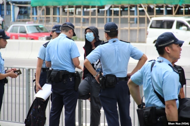 2019年7月7日警察在西九龙高铁车站外对一名行人进行盘查 （美国之音记者申华拍摄）