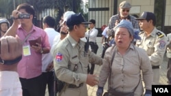 Police ask an activist to stand near the U.S. embassy and wait for officials to receive her petition that calls for U.S. intervention to release union leaders and workers arrested in early January, Phnom Penh, Jan. 21, 2014. (Heng Reaksmey/VOA)