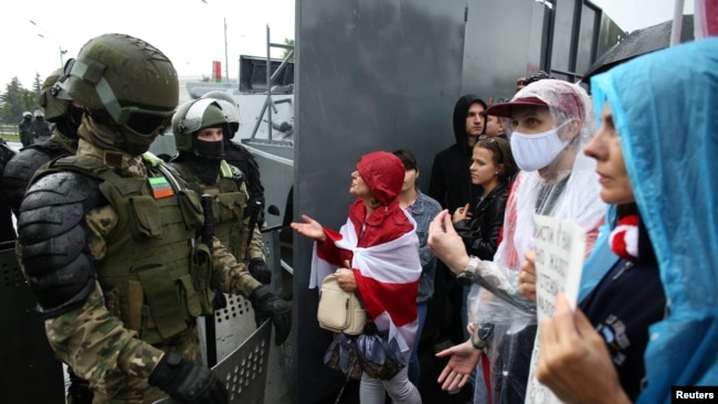 在明斯克参加反对派集会的抗议者冒雨向白俄罗斯安全部队成员喊话。(2020年9月6日)
