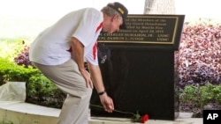 Former U.S. Marine Sgt. Kevin Maloney of Hollywood, Florida, places a flower in front of the plaque dedicated to his fallen comrades Cpl. Charles McMahon and Lance Cpl. Darwin Judge who were the last U.S. servicemen killed in the Vietnam War, during its unveiling ceremony at the U.S. Consulate in Ho Chi Minh City, Vietnam, April 30, 2015.