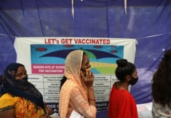 Women stand in a line to get tested for COVID-19 in New Delhi, India, July 2, 2021.