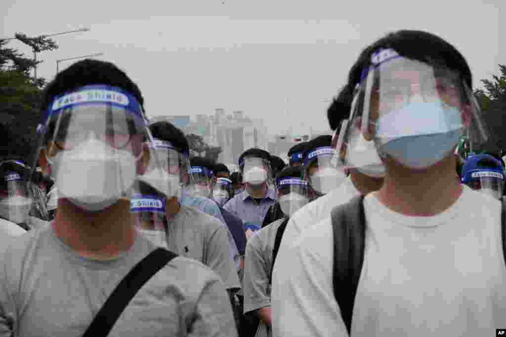 Interns and resident doctors, wearing face shields to protect against COVID-19, attend a rally against the government medical policy in Seoul, South Korea.