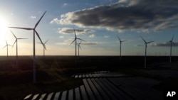 FILE - Wind turbines spin at the Klettwitz Nord solar energy park near Klettwitz, Germany, Oct. 15, 2024. 