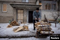 Hennadiy Batsak, de 63 años, recoge madera que utiliza para calentar su apartamento que carece de calefacción, agua y gas en la ciudad fronteriza de Lyman, en medio del ataque de Rusia a Ucrania, el 14 de diciembre de 2023. REUTERS/Thomas Peter