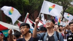 Same-sex marriage supporters wave rainbow Taiwan flags after the Constitutional Court ruled in favor of same-sex marriage outside the Legislative Yuan in Taipei, Taiwan, Wednesday, May 24, 2017. (AP Photo)