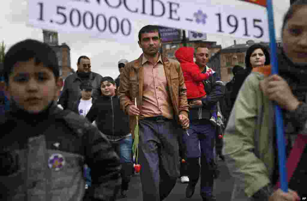 Armenians carry a placard with a sign reading &quot;1915&quot; and &quot;1,500,000,&quot; the year and numbers of victims of mass killings of Armenians by Ottoman Turks on a city street in Yerevan, Armenia, April 24, 2015.
