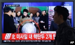 A South Korean army soldier walks by a TV screen showing North Korean leader Kim Jong Un with superimposed letters that read: "North Korea's nuclear warhead" during a news program at Seoul Railway Station in Seoul, South Korea, March 9, 2016.