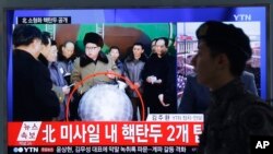 FILE - A South Korean army soldier walks by a TV screen showing North Korean leader Kim Jong Un with superimposed letters that read: "North Korea's nuclear warhead" during a news program at Seoul Railway Station in Seoul, South Korea, March 9, 2016.