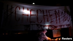 FILE - Activists from the group Chok3 paint a banner with their own blood during a protest discrimination and violence against the gay community in Chechnya and other regions of Russia, outside the Russian Embassy in Mexico City, Mexico, April 20, 2017. 