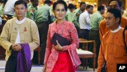 Myanmar opposition leader Aung San Suu Kyi, center, walks along with other lawmakers of her National League for Democracy party as they leave after a regular session of the lower house of parliament, Feb 1, 2016 in Naypyitaw, Myanmar. 